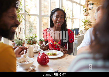 Glückliche junge schwarze Frau essen Brunch mit Freunden in einem Cafe Stockfoto