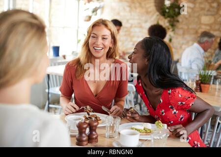 Drei weibliche Freunde reden über Brunch im Café, in der Nähe Stockfoto