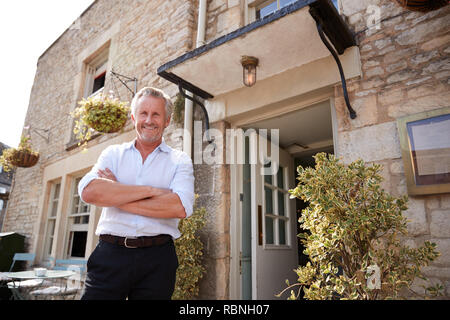 Ältere männliche Restaurant pub Besitzer steht vor dem Eingang Stockfoto