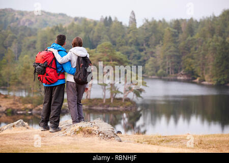 Junge Erwachsene Paar steht auf einem Felsen bewundern Sie den Blick auf den See, Rückansicht Stockfoto