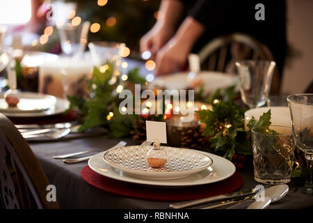 Weihnachten Tischdekoration mit weihnachtskugel Name Kartenhalter auf einer Platte und Grün und Rot Tischdekoration angeordnet Stockfoto