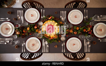 Weihnachten Tischdekoration mit Kugeln auf Platten und grüne und rote Tischdekorationen, Ansicht von oben angeordnet Stockfoto