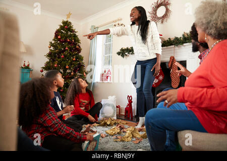 Multi-Generation Familie spielen Spiel des Scharaden, wie Sie Weihnachten feiern zu Hause zusammen Stockfoto