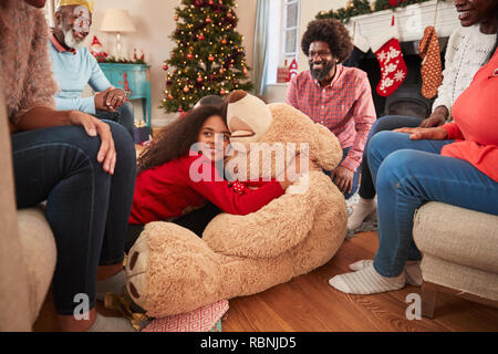 Kinder spielen mit riesigen Teddybär als Multi-Generation Familie Geschenke an Weihnachten Stockfoto