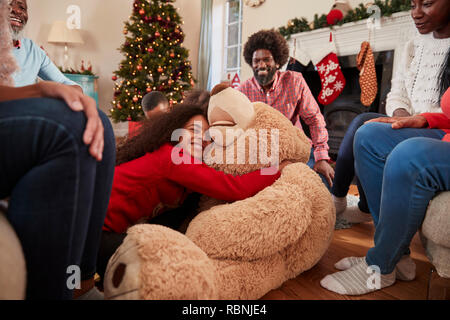 Kinder spielen mit riesigen Teddybär als Multi-Generation Familie Geschenke an Weihnachten Stockfoto