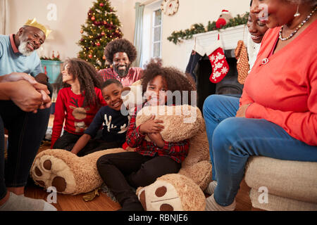 Kinder spielen mit riesigen Teddybär als Multi-Generation Familie Geschenke an Weihnachten Stockfoto