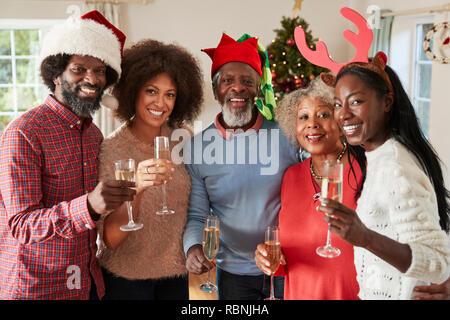 Portrait von Eltern mit erwachsenen Nachkommen einen Toast mit Sekt, wie Sie Weihnachten feiern Stockfoto