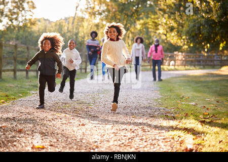 Kinder läuft als Multi-Generation Familie Herbst geniessen in der Landschaft zusammen Stockfoto