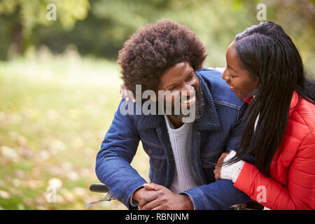 Schwarz Paar verinnerlichen und sich einander lächelnd in einem Park, in der Nähe Stockfoto