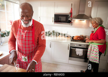 Reifen schwarz Paar Vorbereitung Weihnachtsessen, mann Zerkleinern von Gemüse im Vordergrund. Stockfoto