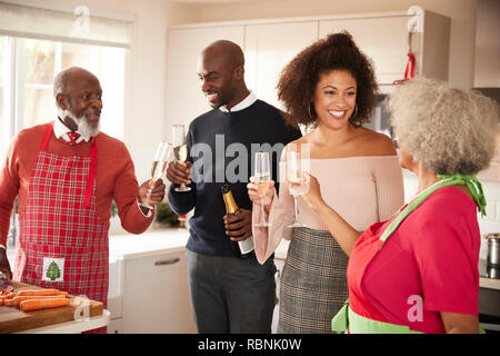 Mischlinge älterer und junger Erwachsener Familie Sektgläser zu feiern, während Weihnachten Abendessen gemeinsam in der Küche, in der Nähe Stockfoto