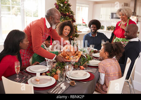 Großvater, der Truthahn auf den Tisch während einer Generation, gemischten Rennen Familie Weihnachten feiern, Erhöhte Ansicht Stockfoto