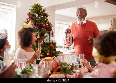 Schwarz Großvater stand eine Rede, und ein Toast an der Spitze der Familie das Weihnachtsessen Tabelle, Ansicht von vorne zu machen Stockfoto
