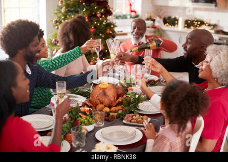 Multi-Generation gemischten Rennen Familie gießen Champagner und Gläsern einen Toast auf das Weihnachtsessen Tisch sitzen, Erhöhte Ansicht zu machen Stockfoto