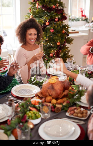 Glückliche junge gemischte Rasse Frau am Weihnachtsessen Tisch sitzen mit Ihrer Familie lächelnd, Erhöhte Ansicht Stockfoto