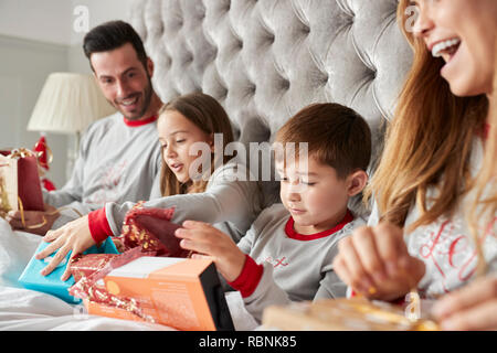 Aufgeregt Familie im Bett zu Hause öffnen Geschenke an Weihnachten Stockfoto