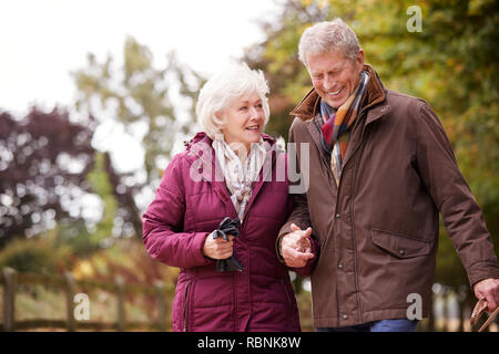 Active Senior Paar auf Herbst zu Fuß auf den Weg durch die Landschaft Stockfoto