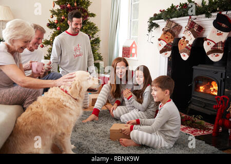 Drei Generation Familie tragen Schlafanzug in der Lounge zu Hause öffnen Geschenke an Weihnachten Stockfoto