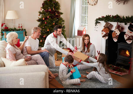 Drei Generation Familie tragen Schlafanzug in der Lounge zu Hause öffnen Geschenke an Weihnachten Stockfoto