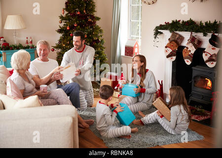 Drei Generation Familie tragen Schlafanzug in der Lounge zu Hause öffnen Geschenke an Weihnachten Stockfoto