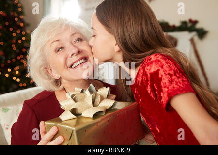 Großmutter empfangen Weihnachtsgeschenk von Enkelin zu Hause Stockfoto