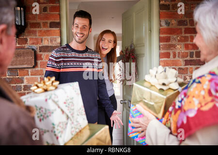 Ältere Eltern von Erwachsenen Nachkommen begrüßt, wie Sie ankommen zu Besuch am Weihnachtstag Stockfoto