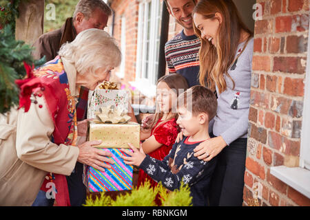 Die großeltern von Familie begrüßt, wie Sie ankommen zu besuchen und an Weihnachten mit Geschenken Stockfoto