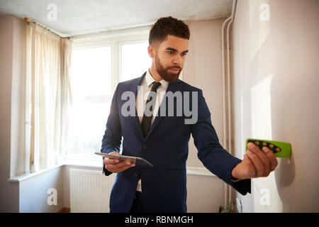 Männliche Realtor mit digitalen Tablet Messraum mit Laser messen. Stockfoto