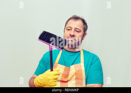 Emotionale bärtiger Mann mit einem Besen. Hellen Hintergrund. Stockfoto