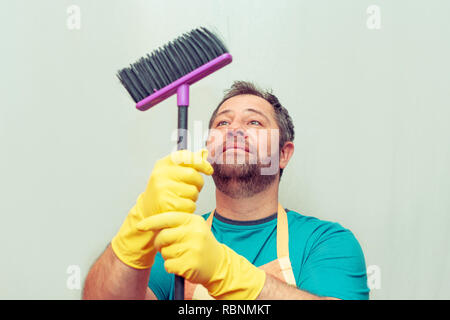 Emotionale bärtiger Mann mit einem Besen. Hellen Hintergrund. Stockfoto