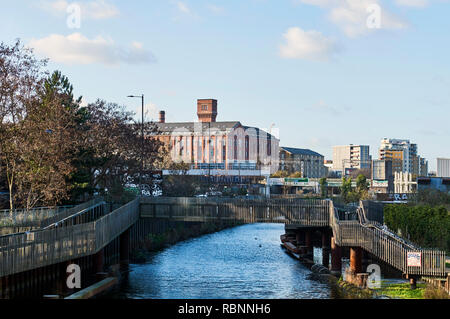 Den Fluss Lea und Steg am Bug, East London Großbritannien, mit dem ehemaligen Bryant & Mai Fabrik gebäude im Hintergrund übereinstimmen Stockfoto