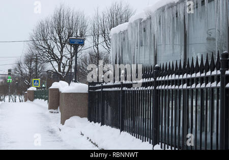 Der von der Decke hängenden lange Eiszapfen im Vordergrund Metallzaun und ein Zeichen in der Ferne mit der Inschrift in der Russischen" 2. Garten Brücke (St. Pe Stockfoto