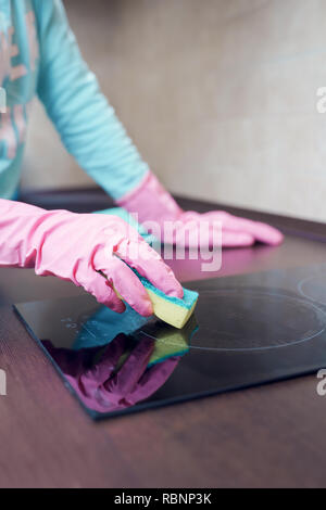 Bild von weiblichen Händen in rosa Gummihandschuhe Waschmaschine Herd Stockfoto