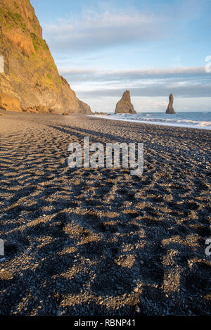 Blick auf Sand Muster der Schwarzen Strand auf Island mit hellen goldenen Felsen im Abendlicht Stockfoto