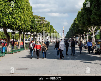 Die Leute gehen entlang der Avenue Habib Bourguiba. Am Ende sieht man den Uhrturm. Stockfoto