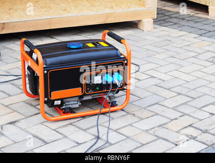 Benzin Portable Generator auf dem Haus Baustelle. Nahaufnahme auf Mobile Backup Generator Notstromaggregat - Outdoor Power Equipment Stockfoto