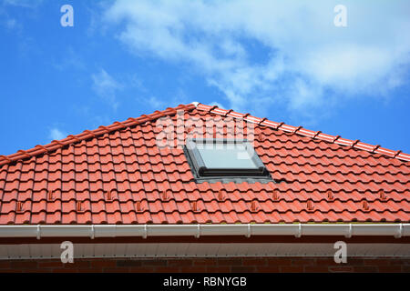 Oberlicht auf rot Keramik fliesen Haus Dach mit Regenrinne. Oberlichter, Dach Windows und Sun Tunneln. Dachgeschoss Dachfenster Lösung outdoor. Stockfoto