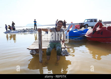 Ein junger Mann sitzt auf der kleinen Mole von Urmia See, West Provinz Aserbaidschan, Iran Stockfoto