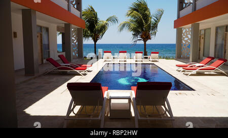 Luxus Hotel mit Schwimmbad, Sonnenliegen, Palmen, Meer. tropisches Resort mit Pool. Travel Concept. Stockfoto