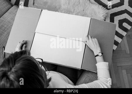 Blick von oben der Frau Auspacken Auspacken weißen Karton mit Online Shopping gut gekauft Stockfoto