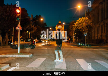 Straßburg, Frankreich - 31.Oktober 2017: Junge männliche Erwachsene crossing Street, Gespräch am Handy und rauchen eine Zigarette mit wunderschönen französischen Architektur im Hintergrund Stockfoto