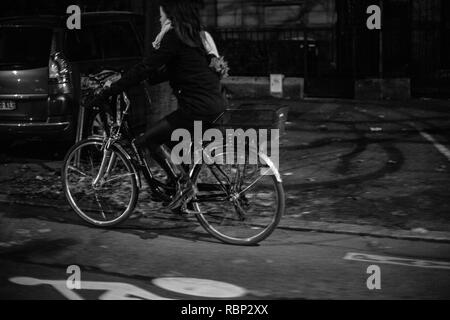 Straßburg, Frankreich - 31.Oktober 2017: Frau das Pendeln mit dem Fahrrad in der französischen Stadt bei Nacht - Schwarz/Weiß-Bild Stockfoto