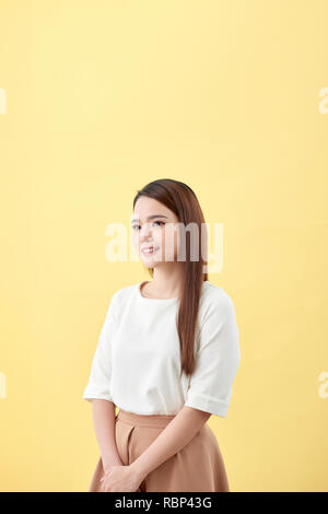 Asiatische Frau lächelnd mit Vertiefung lange Haare schwarz Augen auf gelbem Hintergrund Stockfoto
