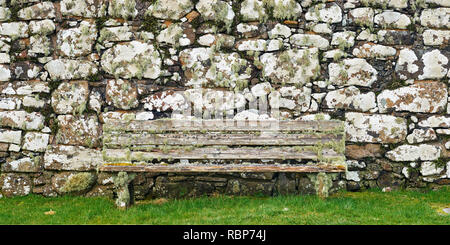 Bank aus Holz und Stein Wand in der Farne und Flechten bedeckt, Kirche, Trumpan Trumpan, Waternish, Isle of Skye, Highland, Schottland Stockfoto