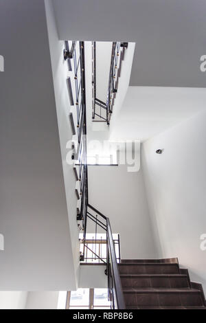 GRODNO, Weißrussland - August 7, 2017: Einen weißen Treppe Notfall- und Evakuierung Ausfahrt Treppe in bis Leiter in ein neues Bürogebäude mit Sonnenschein durch Win Stockfoto