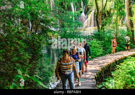 Gruppe von Touristen nimmt Bilder der Wasserfall im Nationalpark Plitvicer Seen, Kroatien Stockfoto