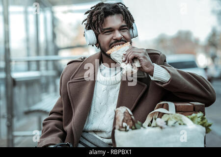 Hungrigen jungen männliche Person essen lecker Gebäck Stockfoto