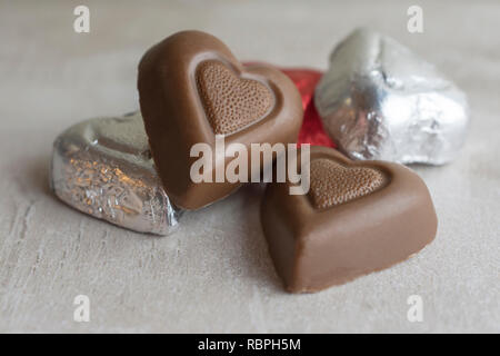 Gruppe von Herz Schokolade auf tan Fliese. Nähe zu sehen. Stockfoto