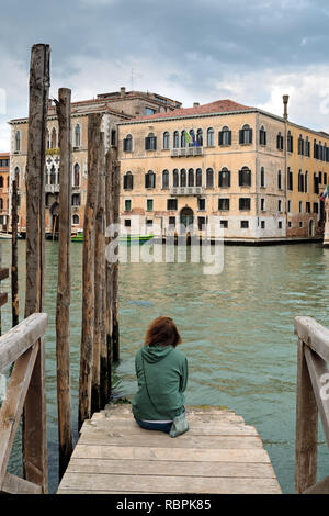 Person sitzt auf Gangway, Ansicht von hinten. Canal Grande, Venedig Stockfoto