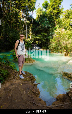 Hübscher junger kaukasischer Mann auf erstaunliche Kuang Si Wasserfall in der Nähe von touristischen Luang Prabang in Laos. Menschen und Landschaft der Natur in Südostasien dur Stockfoto